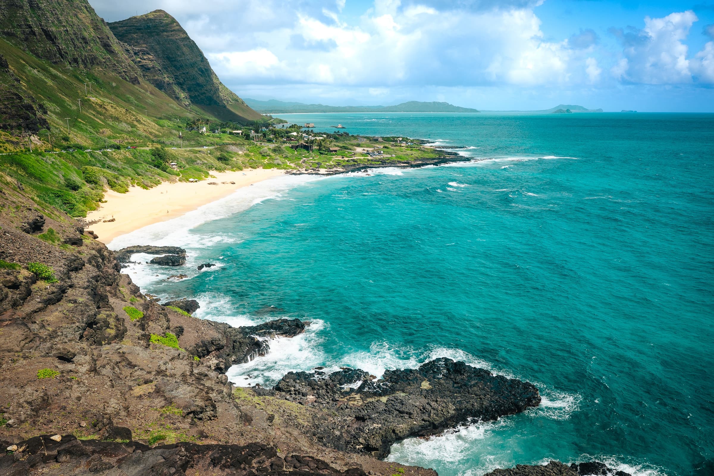 Turquoise ocean meeting a rocky green coastline